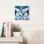 Reloj Cuadrado Cojín decorativo Art Deco Swan and Lilies<br><div class="desc">Un cisne blanco extiende sus alas sobre los azulejos de arte deco sobre un bonito fondo azul.</div>