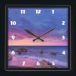 Reloj Cuadrado Hermosa fotografía de la costa atardecer<br><div class="desc">Un reloj con una bonita fotografía con llamativos colores morados,  azules y rosas al atardecer. Una línea costera de bonito con rocas.</div>