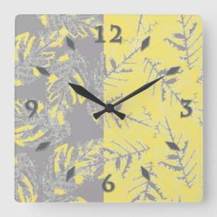 Reloj Cuadrado Hojas grises y amarillas en un fondo rayado.