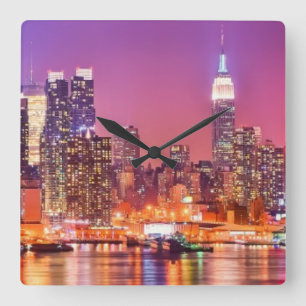 Reloj Cuadrado Midtown Manhattan en la noche con el imperio Stae