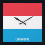 Reloj Cuadrado Patriótico de Bandera Nacional de Luxemburgo<br><div class="desc">Bandera nacional luxemburguesa reloj de pared de la Plaza Patriótica con la bandera del país en los colores nacionales impresos a lo largo de las 24 horas. El nombre del país está sutilmente integrado en el diseño de la parte inferior. El texto es totalmente personalizable usando la función "Personalizar". Este...</div>