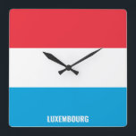 Reloj Cuadrado Patriótico de Bandera Nacional de Luxemburgo<br><div class="desc">Bandera nacional luxemburguesa reloj de pared de la Plaza Patriótica con la bandera del país en los colores nacionales impresos a lo largo de las 24 horas. El nombre del país está sutilmente integrado en el diseño de la parte inferior. El texto es totalmente personalizable usando la función "Personalizar". Este...</div>