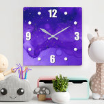 Reloj Cuadrado Resumen de color morado con estrellas de Purpurina<br><div class="desc">Pequeñas estrellas doradas se tambalean sobre un fondo de acuarela abstracto morado y azul oscuro. Relájese en su habitación favorita con este impresionante y vibrante reloj de pared. Tu elección de una cara de reloj redonda o cuadrada. ¡Hace un gran regalo de bienvenida! Puede personalizar fácilmente este reloj de pared....</div>