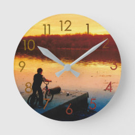 Reloj de pared de niño en bicicleta al atardecer