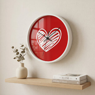 Reloj de pared moderno con corazón rojo enmarcado