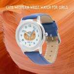 Reloj De Pulsera Un Gato Occidental Y Un Nombre Verde azulado<br><div class="desc">Este lindo reloj de muñeca diseñado por un gato occidental es para niños. El diseño se inspiró en las viejas alfombras tejidas del nativo americano Rio Grande. Los colores de la tierra son ocre, marrón, turquesa y arcilla roja. Estos ojos verde azulados salen de una cara de reloj fácil de...</div>