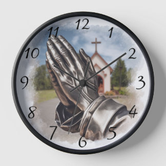 Reloj Manos rezando con una iglesia de aspecto plateado 