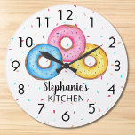 Reloj Redondo Grande Cocina de Donut Personalizada<br><div class="desc">Este divertido reloj está decorado con tres donuts en azul, rosa y amarillo sobre un fondo rociado. Personalizable fácilmente con tu nombre. Utilice la opción Personalizar adicional para cambiar el tamaño, estilo o color del texto si lo desea. Porque creamos nuestra propia obra de arte no encontrarás esta imagen exacta...</div>