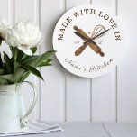 Reloj Redondo Grande Hecho con amor en la panadería Whisk de la cocina<br><div class="desc">Diseño de relojes de panadería sencillos, limpios y minimalistas con "hecho con amor en la cocina de Nana. Los falsos panaderos de madera natural que rodan el pin y el diseño de whisky se están cruzando unos a otros y se colocan en el centro del reloj. Personalizar con iniciales de...</div>