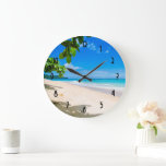 Reloj Redondo Grande Hermosa foto soleada de playa tropical<br><div class="desc">Un reloj con una hermosa fotografía. Una playa de arena blanca y agua azul cielo. Una imagen relajante con un cielo soleado y un suave surf de espuma con algunas bonitas hojas tropicales enmarcando la imagen.</div>