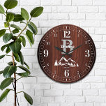 Reloj Redondo Grande Nombre de familia de la montaña<br><div class="desc">Diversión,  nombre familiar personalizado y diseño de monograma. Hace el regalo perfecto para una casa caliente,  boda o cualquier ocasión! Picos de montaña nevados de invierno y pinos en un profundo y rico panel falso de madera de arce.</div>