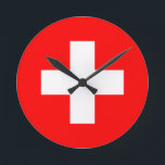 Reloj Redondo Mediano bandera de suiza<br><div class="desc">La bandera de Suiza (alemana: Schweizerfahne; francesa: drapeau de la Suisse; italiana: bandiera svizzera; románica: bandiera de la Svizra) muestra una cruz blanca en el centro de un campo cuadrado rojo. La cruz blanca es conocida como la cruz suiza.</div>