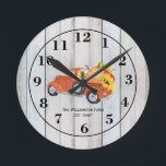 Reloj Redondo Mediano Calabazas de camión de vintage girasoles nombre gr<br><div class="desc">Un reloj perfecto para cualquier casa de campo o en cualquier lugar que necesite un toque de casa de campo. Un camión de recolección vintage lleva una cama llena de calabazas recién cosechadas y girasoles amarillos vívidos sobre un fondo rústico de madera gris. El reloj se personaliza con tu nombre...</div>