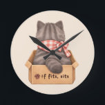 Reloj Redondo Mediano Gato en la caja<br><div class="desc">Gato gris esponjoso sentado cómodamente dentro de una caja de cartón. El texto "Si cabe,  se sienta" expresa la regla de comportamiento innata del gato.</div>