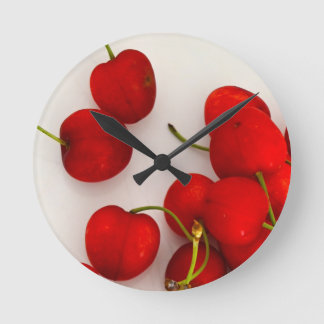 Reloj Redondo Mediano Las cerezas rojas con luz natural yacen en blanco