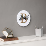 Reloj Redondo Mediano Moderno y elegante nombre de monograma Black Gold<br><div class="desc">El moderno y elegante Monograma Denominación Black Gold Script Clock es un reloj elegante y personalizado perfecto para cualquier hogar u oficina. Este reloj presenta una cara negra elegante con un guión dorado elegante, que le permite personalizar con su monograma y nombre. El diseño moderno y los colores sofisticados lo...</div>