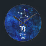 Reloj Redondo Mediano Monograma azul de la galaxia de la constelación<br><div class="desc">Diseño azul del monograma de la galaxia de la constelación del zodiaco del virgo con la fuente cepillada de moda de la escritura, la textura celestial azul marino del fondo de la acuarela, la constelación de la estrella que brilla intensamente, y el símbolo virginal. ¡El horóscopo astrológico moderno del nacimiento...</div>