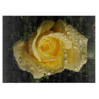 Rosa amarillo con la tabla de cortar del rocío