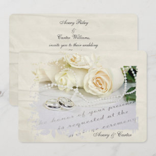 rosas blancas y anillos en la invitación a la boda
