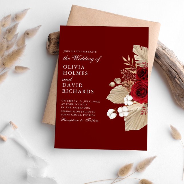 Rosas de Borgoña y la invitación a la boda de Gras (Burgundy Roses and Pampas Grass Wedding Invitation on a table surrounded with pampas grass.)