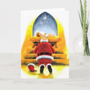 Santa que se arrodilla antes de tarjeta de Navidad