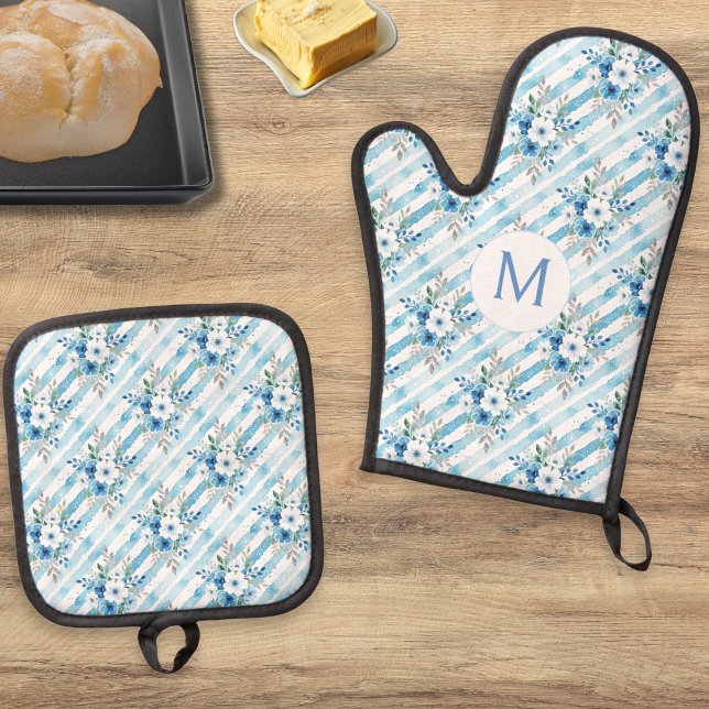 Set De Manoplas Cocina Campestre Personalizada con Flores Azules a (A monogrammed oven mitt and pot holder set with blue and white floral stripe and green leaf pattern)