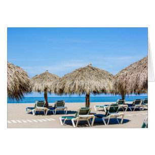 Sillones y paraguas de la paja en la playa