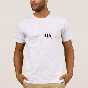 Silueta de pájaros negros en camiseta con cable