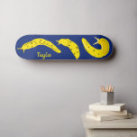 Skateboard Banana corre con el amarillo y el azul real person<br><div class="desc">Crea un regalo personalizado que es perfecto para todo aquel que ame criaturas tremendas. Este patinador presenta ilustraciones de babosas de plátano en un marco amarillo alegre y alegre con un fondo azul real. Hay un punto para agregar un nombre en las letras amarillas coincidentes.</div>