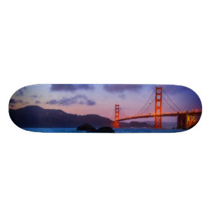 Skateboard Después de puesta del sol hacia fuera en la playa