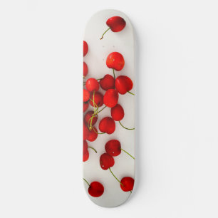 Skateboard Las cerezas rojas con luz natural yacen en blanco