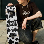 Skateboard Monograma blanco y negro de impresión en animales<br><div class="desc">Las vacas blancas y negras ocultan patineta con letra monográfica. Diseño unisex para hombres y mujeres. Adecuado para niños y adultos. Excelente para temas de cowboy/cowgirl country.</div>