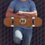 Skateboard Monograma moderno de oro de cuero de acero<br><div class="desc">Diseño monográfico moderno con tipografía clásica en bloques inicial sobre un emblema de oro metálico de moda con su nombre debajo sobre un fondo de cuero marrón estable.</div>