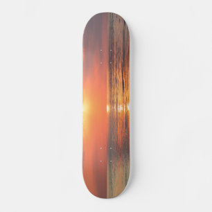 Skateboard puesta de sol sobre el agua