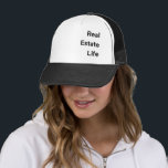 Sombrero de camionero<br><div class="desc">¡Acepte la 'Vida Real' con nuestro elegante sombrero de camionero! Perfecto para profesionales y entusiastas de la industria, este gorra exuda estilo y pasión en una declaración audaz. Con un diseño clásico y un ajuste cómodo, es el accesorio ideal para mostrar tu amor por el ajetreo inmobiliario. ¡Eleva tu apariencia...</div>
