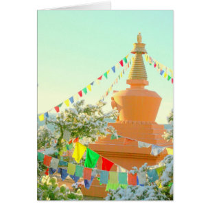 Stupa budista con banderas de oración en la nieve