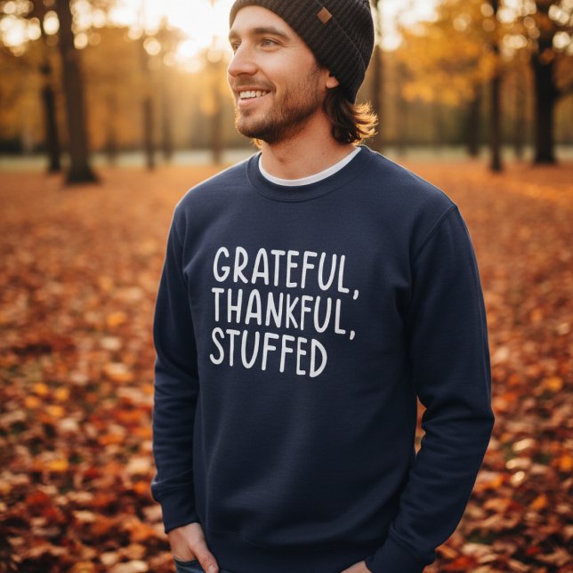 Sudadera Grateful Thankful Stuffed • Funny Thanksgiving (Man wearing navy sweater with text “Grateful, Thankful, Stuffed” in autumn park)