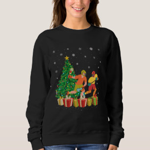 Sudadera Navidad Jugador de hockey Santa Hat iluminando árb