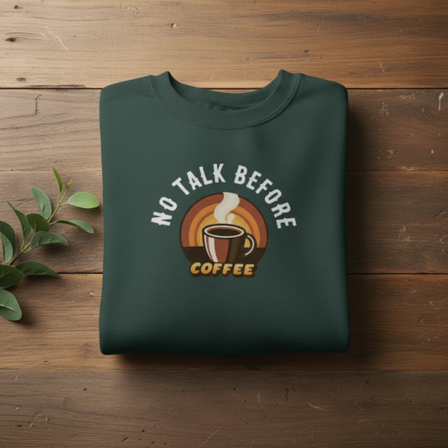 Sudadera No Talk Before Coffee • Funny Coffee Lover (folded dark green No Talk Before Coffee sweatshirt on wooden background with leaves)