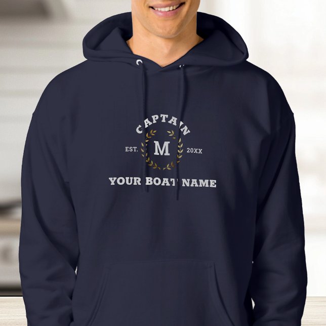 Sudadera Personalizado Capitán Bote Monograma Laurel Náutic (A person in a navy hoodie with "Captain" text and laurel wreath design. )