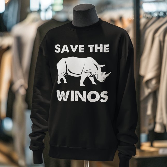 Sudadera "Salven a los Winos" Rinoceronte divertido (Black sweatshirt with "Save the Winos" and a rhino graphic displayed on a mannequin in a clothing bo)