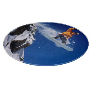 Tabla De Cortar Hombre en una snowboard saltando desde una cornisa