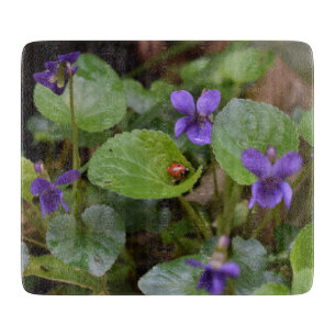 Tabla De Cortar Ladybug sobre las dulces flores violetas