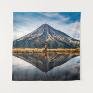 Tapiz Un montañista con un vestido naranja en una simetr