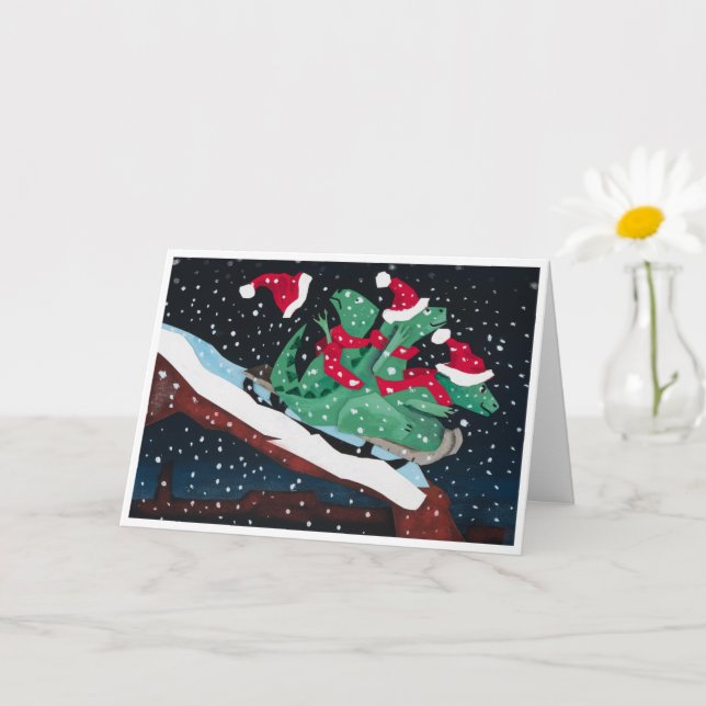 Tarjeta A whimsical holiday card with sledding dinosaurs (Planta pequeña)