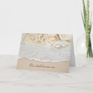 Tarjeta anillos de boda sobre pétalo rosa