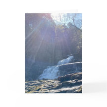 Cascada, rocas y rayos de sol