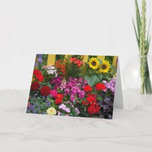 Tarjeta Cerca de estacas amarillas con jardín de flores en
