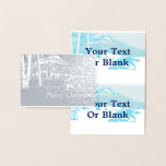 Tarjeta Con Relieve Metalizado Lobo solitario en WInter<br><div class="desc">Un lobo (Canis lupus) se abre paso a través de un paisaje nevado de abedules y montañas en esta imagen estilizada y monótona azul. También aparece el texto "Feliz Navidad". Añade tu propio texto adicional.</div>