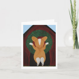 Tarjeta Corgi poniendo corona de Navidad en la casa del pe